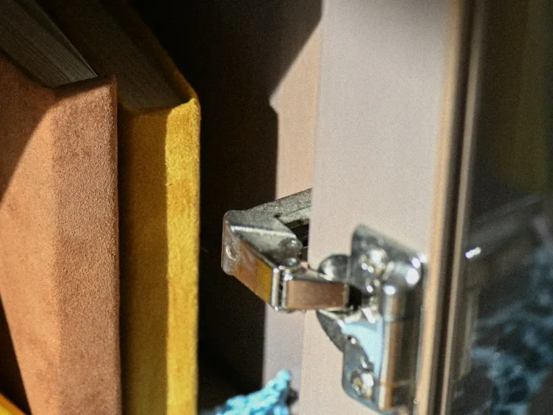 Concealed hinge fitted to the frame of a glass cabinet door